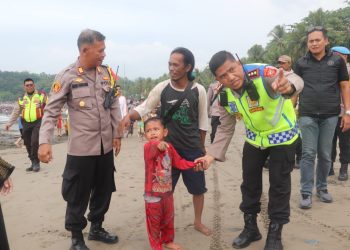Kapolres Sukabumi Tenangkan Anak yang Terpisah dari Orang Tuanya di Pantai Karanghawu